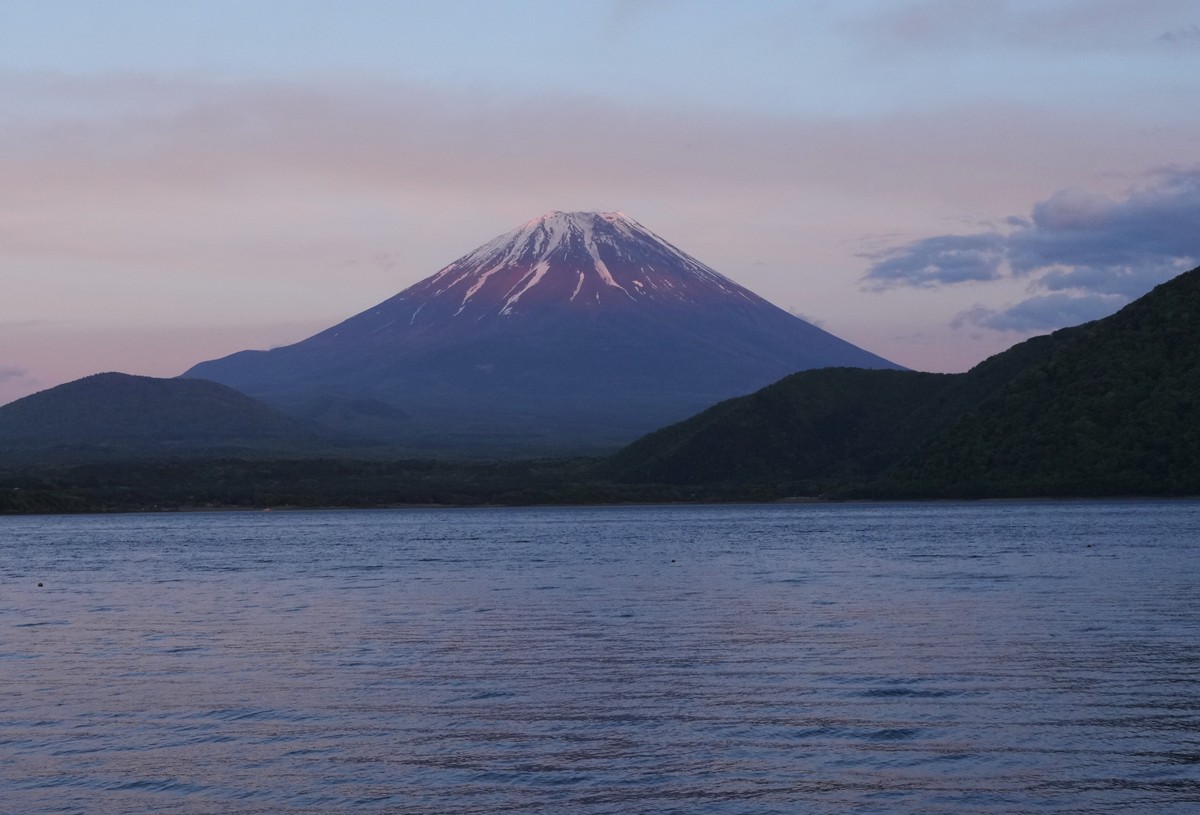 KEYPIX - Family members sit by Lake Motosu as the color of sunset is reflected on Mount Fuji, as seen from a campsite in Minobucho, west of Tokyo, Saturday, May 9, 2026. (KEYSTONE/AP Photo/Hiro Komae)
