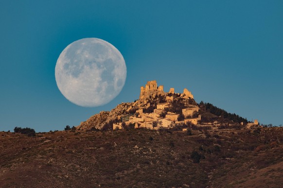 Cold Full Moon Over Rocca Calascio, Italy Cold full moon sets behind Rocca Calascio castle and village in Calascio, Italy, on December 16th, 2024. Celts renamed the december full moon as theCold Moon. ...