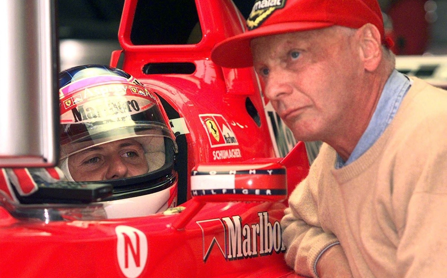 ARCHIV - Ferrari-Fahrer Michael Schumacher, links, und der fruehere Formel 1-Weltmeister Nicki Lauda waehrend des Trainings auf dem A1-Ring in Zeltweg, Oesterreich, am 25. Juli 1998. Lauda ist der Mei ...