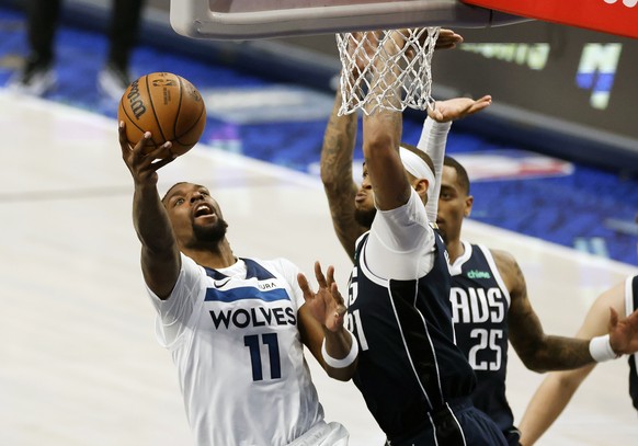 epa11376700 Minnesota Timberwolves center Naz Reid (L) makes a shot over Dallas Mavericks center Daniel Gafford (R) during the second half of the NBA Western Conference Finals playoff game four betwee ...