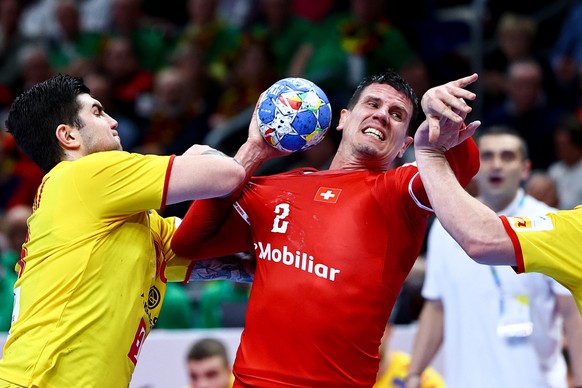 epa11083437 Switzerland&#039;s Andy Schmid (L) in action against North Macedonia&#039;s Milan Lazarevski during the Men&#039;s EHF EURO 2024 Handball preliminary round ? group A match between North Ma ...