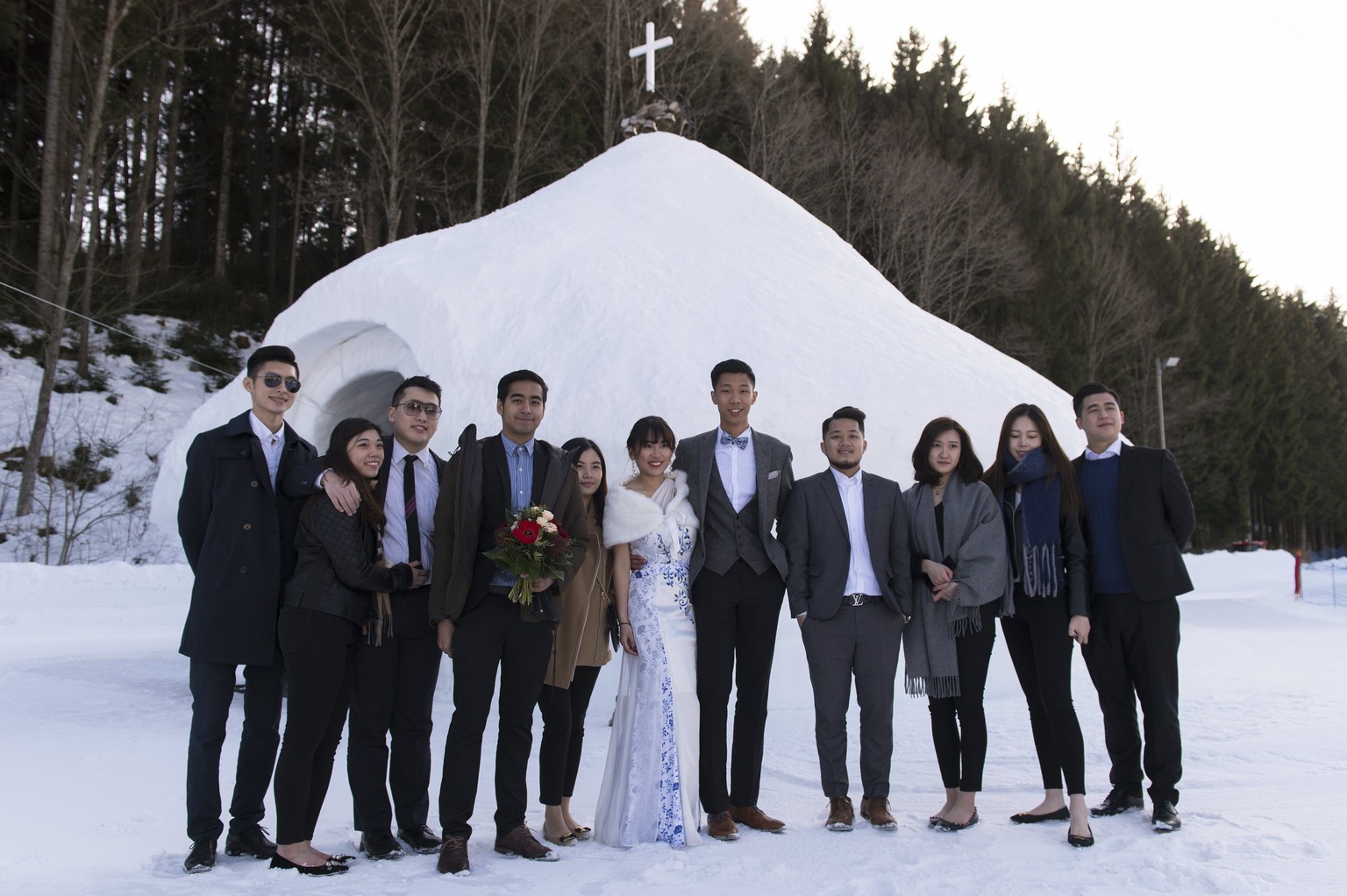 epa05793120 Newlyweds Chinese young people and their guests pose for a picture on the Valentine&#039;s Day, in the Swiss Alps Resort of Leysin, Switzerland, 14 February 2017. An ice church is a new at ...