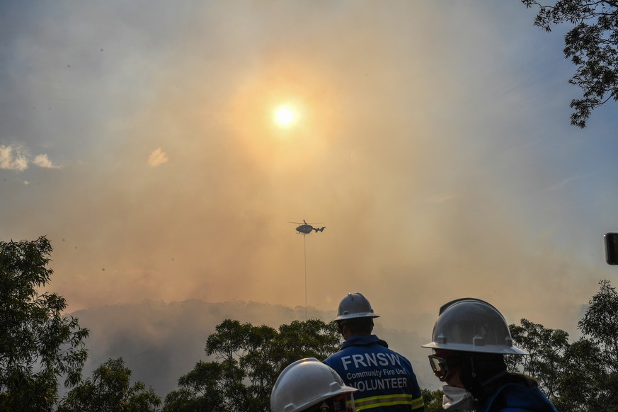 epa06670389 Water bombers are seen fighting a bushfire in Alfords Point as fire crews watch and wait in Sydney, Australia, 15 April 2018. Media reports on 14 April 2018 state that more that 100 firefi ...