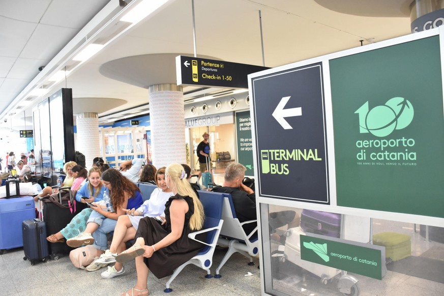 epa13166960 Travelers at Fontanarossa Airport in Catania, Italy, 13 August 2026. All flights arriving at and departing from Catania Airport have been suspended due to heavy ashfall caused by activity  ...
