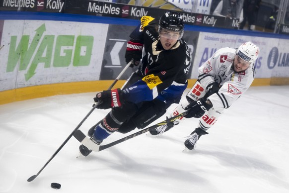 Gotterons Janne Kuokkanen, links, und Luganos Elia Riva, rechts, kaempfen um den Puck, beim Eishockey Meisterschaftsspiel der National League A zwischen den HC Fribourg Gotteron und HC Lugano, am Dien ...