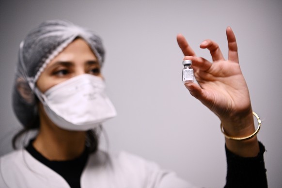 epa08922731 A health worker holds a vial containing the Pfizer-BioNTech COVID-19 vaccine in Aulnay-sous-Bois, France, 06 January 2021, as several French medical representatives and personalities receive the vaccine. France began its coronavirus disease (COVID-19) vaccination campaign on 27 December 2020. The French government has faced criticism over the slow progress of its drive to vaccinate people, a problem compounded by the high levels of public skepticism about the campaign.  EPA/CHRISTOPHE ARCHAMBAULT / POOL  MAXPPP OUT