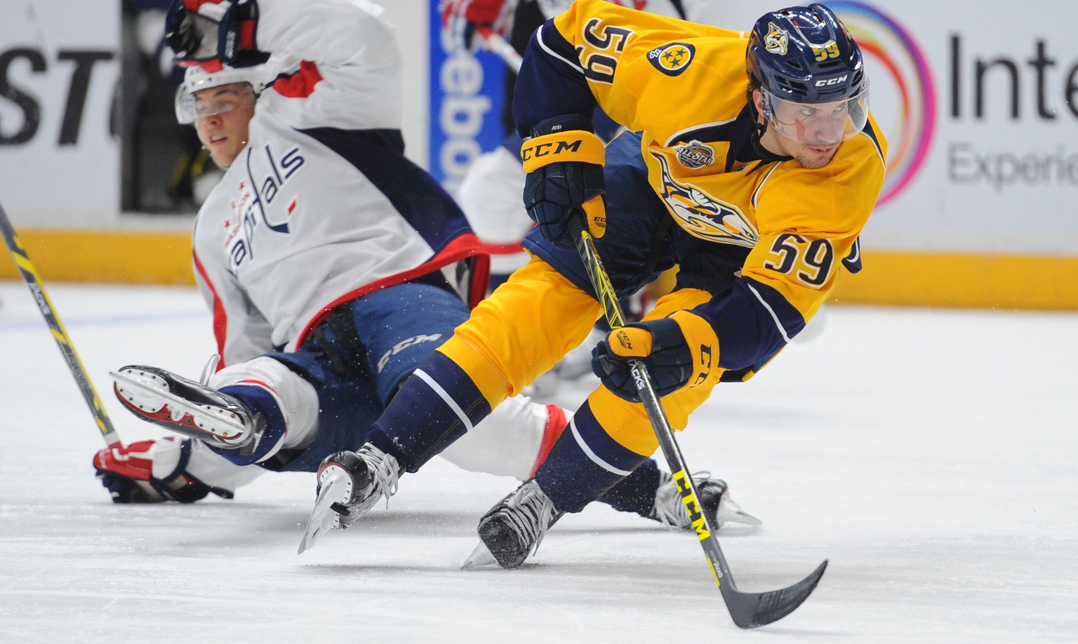 Feb 9, 2016; Nashville, TN, USA; Nashville Predators defenseman Roman Josi (59) skates with the puck as Washington Capitals left winger Andre Burakovsky (65) falls during the second period at Bridgest ...