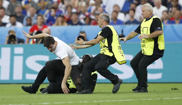 Football Soccer - Portugal v France - EURO 2016 - Final - Stade de France, Saint-Denis near Paris, France - 10/7/16
Stewards tackle a fan who invades the pitch
REUTERS/Carl Recine
Livepic