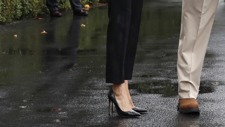 President Donald Trump, accompanied by first lady Melania Trump, gives a thumbs-up as they walk to Marine One on the South Lawn of the White House in Washington, Tuesday, Aug. 29, 2017, for a short tr ...