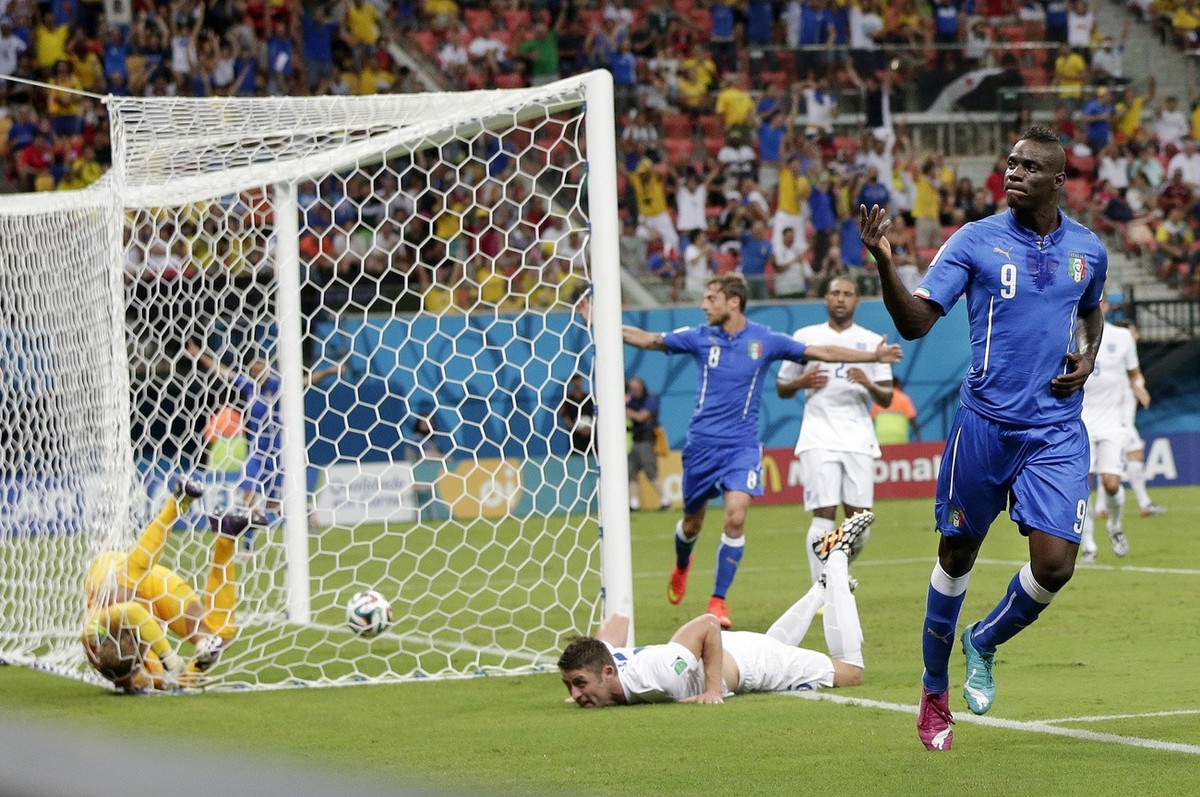 Italy's Mario Balotelli (9) celebrates after getting the ball past England's goalkeeper Joe Hart, left, and Gary Cahill, center, to score his side's second goal during the group D World ...