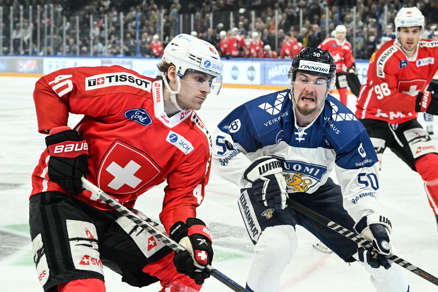 epa09928503 Swizterland ?s Andre Heim (L) and Finland ?s Mikael Seppala (R) in action during the EHT ice hockey match between Finland and Switzerland in Tampere, Finland, 05 May 2022. EPA/KIMMO BRANDT