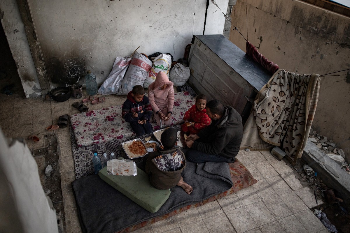 epa11230153 Internally displaced Palestinian Muhammad al-Durra, 41, from Gaza City prepares for Iftar, the fast-breaking evening meal during the Muslim holy month of Ramadan, with his children in a de ...