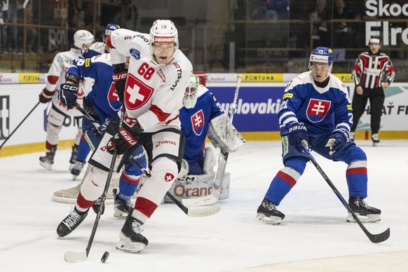 epa12894110 Fabrice Herzog of Switzerland, left, vies for the puck with ahead of Adam Ziak of Slovakia, right, during a friedly ice hockey match between Slovakia and Switzerland in Topolcany, Slovakia ...