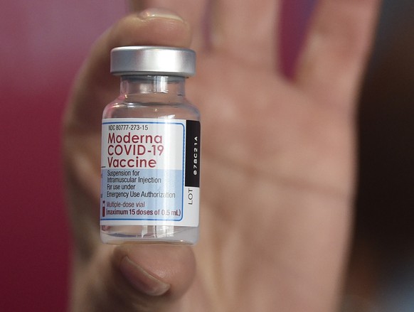 A health worker shows a vial of the Moderna vaccine for COVID-19, donated by the US government, at a health center in Quilmes, Argentina, Tuesday, Aug. 3, 2021. Argentina is vaccinating youths with pr ...