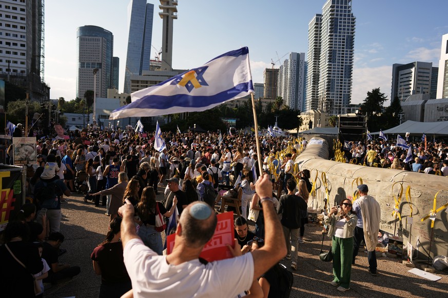 People gather to watch a live broadcast of Israeli hostages released from Gaza at a plaza known as hostages square in Tel Aviv, Israel, Monday, Oct. 13, 2025. The release took place as part of a cease ...