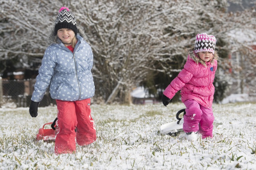 Zwei Maedchen spielen im frisch gefallenen Schnee, am Dienstag, 3. Januar 2017, in der Naehe von Huttwil. Nach einer langen Trockeperiode fiel in der Nacht zum Dienstag in weiten Teilen der Schweiz Sc ...