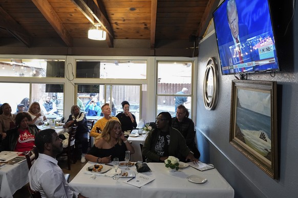 People watch the presidential debate between Republican presidential nominee former President Donald Trump and Democratic presidential nominee Vice President Kamala Harris, Tuesday, Sept. 10, 2024, in ...