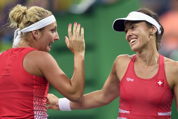epa05460640 Martina Hingis (R) and Timea Bacsinszky (L) of Switzerland celebrate a point against Daria Gavrilova and Samantha Stosur from Australia after the women&#039;s first round doubles match of  ...
