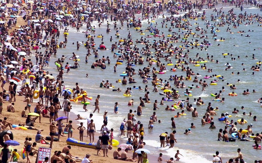 People enjoy their leisure time at the crowded &#039;Hui Quan Bay&quot; near Qingdao city, China on Saturday, 13 August 2005. On hot summer days, up to 200,000 people use to pass their time at the bea ...