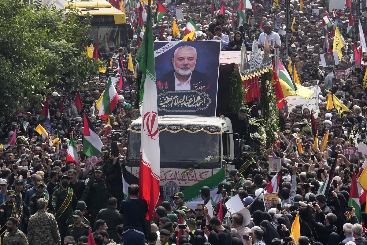 Iranians follow a truck, center, carrying the coffins of Hamas leader Ismail Haniyeh and his bodyguard who were killed in an assassination blamed on Israel on Wednesday, during their funeral ceremony  ...