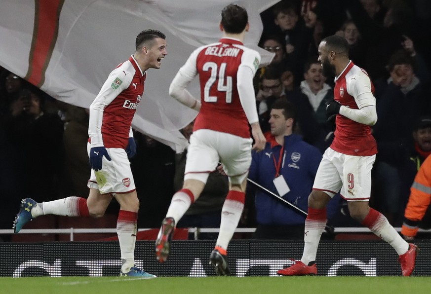 Arsenal&#039;s Granit Xhaka, left, celebrates with his teammates Hector Bellerin, center, and Alexandre Lacazette after scoring his side second goal during the English League Cup semifinal second leg  ...