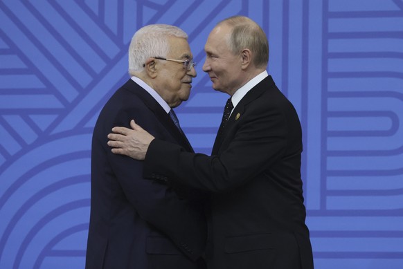Russian President Vladimir Putin, right, embraces Palestinian President Mahmoud Abbas during a welcoming ceremony prior to a festive reception at BRICS Summit in Kazan, Russia, Wednesday, Oct. 23, 202 ...