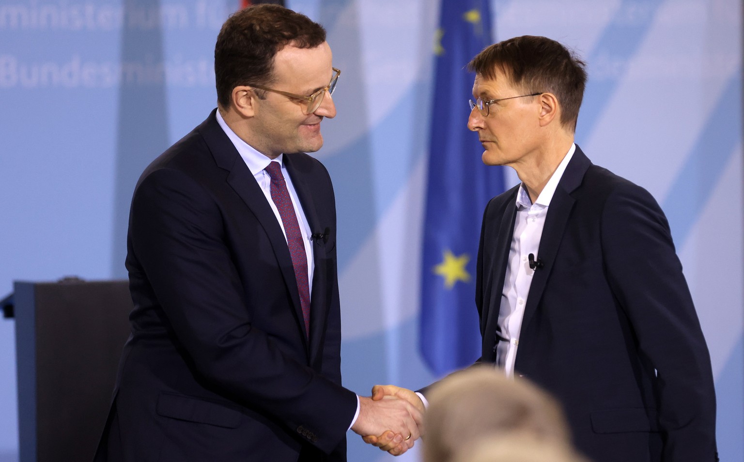 epa09629721 Former German Health Minister Jens Spahn (L) congratulates German Health Minister Karl Lauterbach (R) during the official handover ceremony at the health ministry in Berlin, Germany, 08 De ...