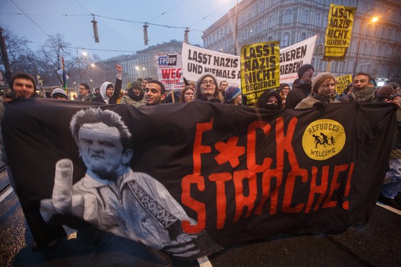 epa06436246 People carry a banner reading &#039;f&#039;ck strache&#039; as they take part in a protest against the new coalition government between Austrian Peoples Party (OeVP) and the right-wing Aus ...