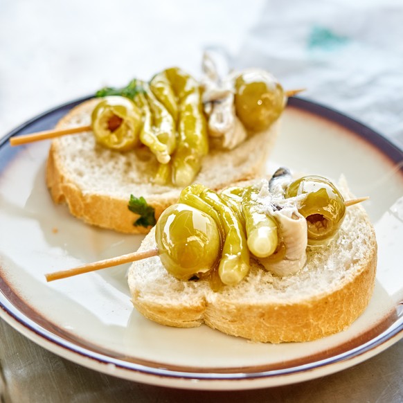 Mini-Spiesschen mit Oliven, Chilischoten und Sardellenfilets.
