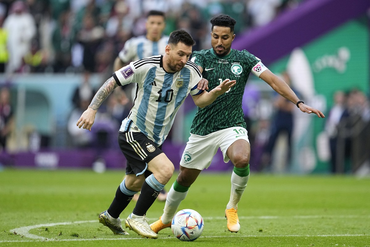Argentina's Lionel Messi,left, and Saudi Arabia's Salem Al-Dawsari, fight for the ball during the World Cup group C soccer match between Argentina and Saudi Arabia at the Lusail Stadium in L ...