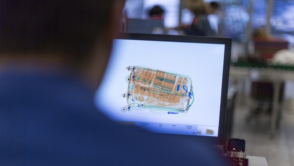 EDITOR&#039;S NOTE: NAME OF EMPLOYEE ON SCREEN HAS BEEN DIGITALLY REMOVED. Security personnel of the Police of the Canton of Zurich check the hand baggage of air passengers and airport employees at th ...