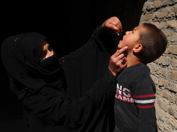 epa09108262 A polio worker administers vaccination to Afghan children, a day after three female polio workers were killed in Jalalabad, in Herat, Afghanistan, 31 March 2021. Three female workers, who  ...