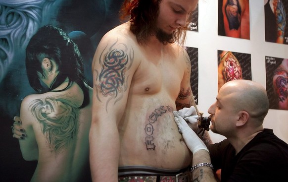 A young man gets a tattoo during the third international tattoo and piercing festival in Kiev on Friday, 09 February 2007. More than 40 artists from Russia, Ukraine, Belarus, Poland and Czech Republic ...