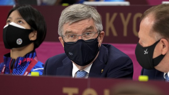 President of the IOC Thomas Bach, left, chats with a delegate as he watching the men&#039;s -73kg judo semifinal match, at the 2020 Summer Olympics in Tokyo, Japan, Monday, July 26, 2021. (AP Photo/Vi ...