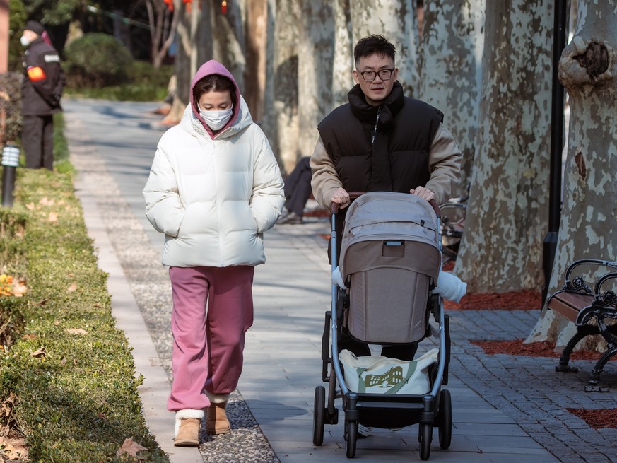 epa10410133 A family walk in the park, in Shanghai, China, 17 January 2023. China?s population dropped from 1.41260 in 2021 to 1.41175 billion people in 2022. It is the first decline since 1961, accor ...