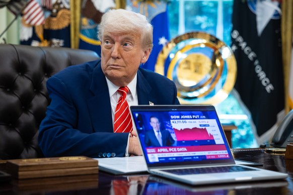 epa12146167 US President Donald Trump sitting near a computer playing a news report about the stock market during a press conference in the Oval Office at the White House in Washington, DC, USA, 30 Ma ...