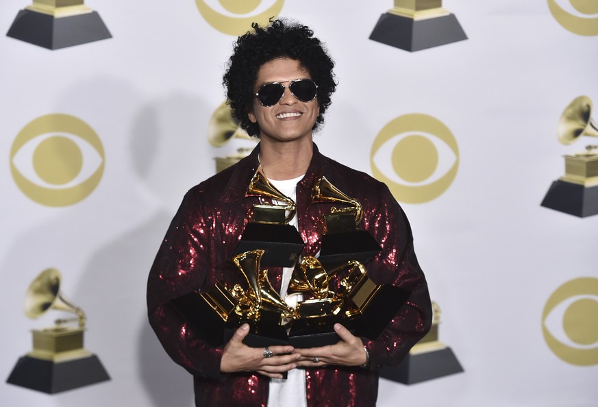 Bruno Mars poses in the press room with his awards for best R&amp;B album, record of the year, album of the year, best engineered album, non-classical, for &quot;24K Magic,&quot; and song of the year, ...