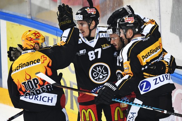 Luganos Luca Fazzini, Mitte, feiert mit den Mitspielern Dario Buergler, links, und Tony Martensson, rechts, das 3-0 Goal im Spiel beim Eishockey Meisterschaftsspiel der National League A zwischen dem  ...