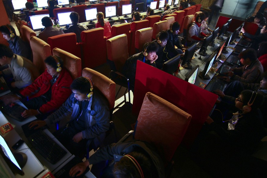 FILE - In this March 12, 2010 file photo, people use computers at an Internet cafe in Fuyang, in central China&#039;s Anhui province. The number of online microblog users in China dropped by more than ...