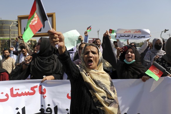 Afghan women shout slogans and wave Afghan national flags during an anti-Pakistan demonstration, near the Pakistan embassy in Kabul, Afghanistan, Tuesday, Sept. 7, 2021. Sign in Persian at right reads ...