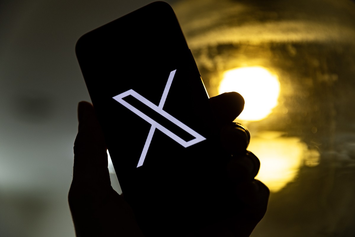 epa10772440 An illustration pictures shows a user holding a mobile phone displaying the 'X' logo, in Los Angeles, California, USA, 27 July 2023. Twitter announced on 23 July that it will reb ...