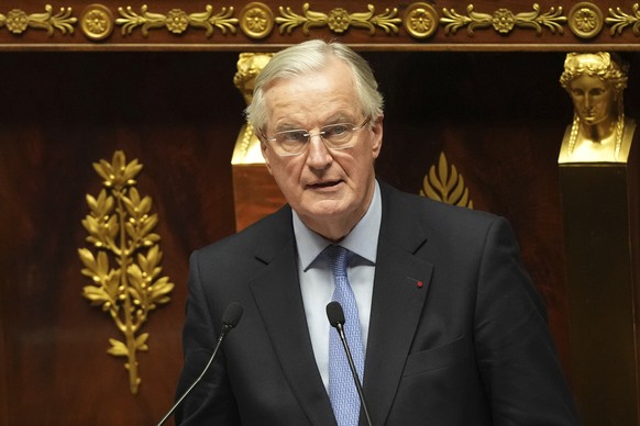 French Prime Minister Michel Barnier addresses the National Assembly prior to a vote on a no-confidence motion that could bring him down and his cabinet for the first time since 1962, Wednesday, Dec.  ...
