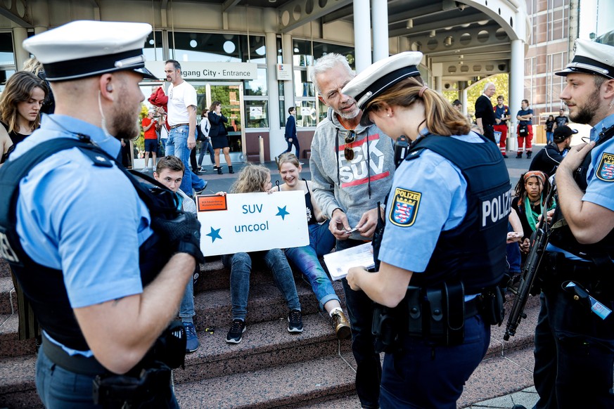 epa07842180 Police officers talk to climate activists at the entrance of the IAA 2019 International Motor Show during a demonstration in Frankfurt, Germany, 14 September 2019. The 2019 International M ...