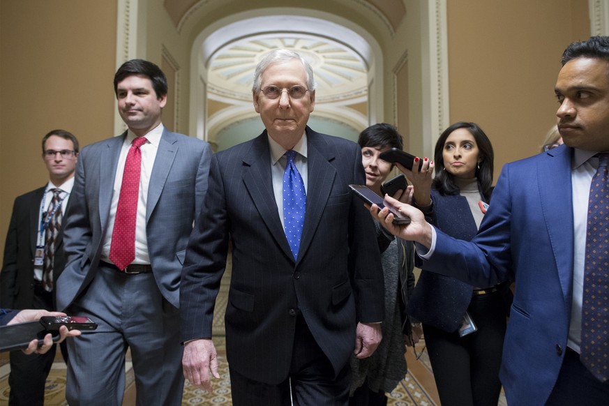 epa07241064 Senate Majority Leader Republican Mitch McConnell (C) is followed by members of the news media as he walks from the Senate floor to his office on Capitol Hill in Washington, DC, USA, 19 De ...