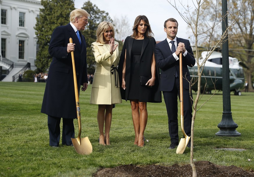 epa06688014 US President Donald J. Trump (L) and First Lady Melania Trump (2R) pose with French President Emmanuel Macron (R) and his wife Brigitte Macron (2L) as they participate in a tree planting i ...