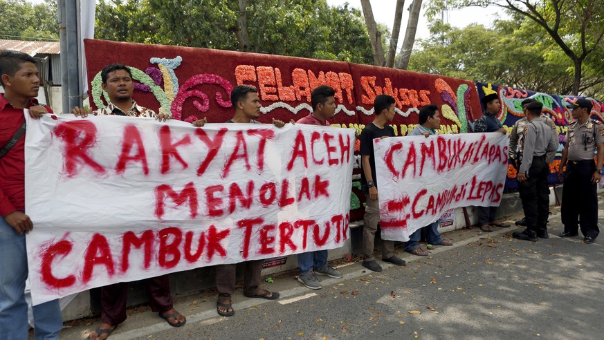 epa06663591 Acehnese student activists hold a banner reading &#039;Aceh people reject canning punishment being held in closed areas&#039; against the local government&#039;s decision to no longer hold ...