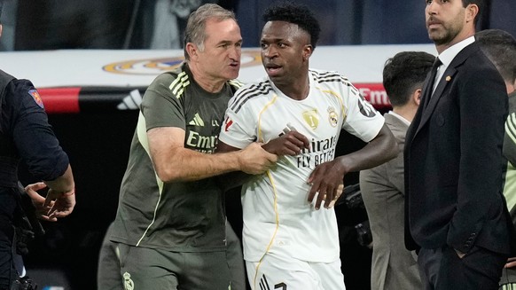 Real Madrid&#039;s Vinicius Junior is restrained by coaching staff duringa post match scuffle at La Liga soccer match between Real Madrid and Barcelona in Madrid, Spain, Sunday, Oct. 26, 2025. (AP Pho ...