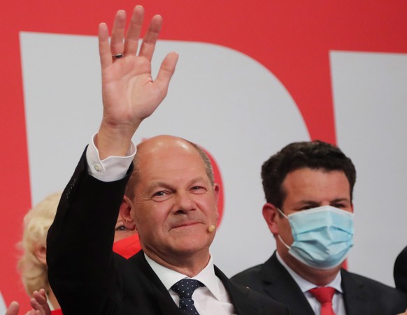 epa09491628 German Finance Minister and SPD candidate for chancellor Olaf Scholz waves on stage during the Social Democratic Party (SPD) election event in Berlin, Germany, 26 September 2021. About 60  ...