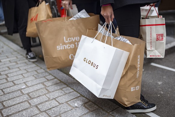 Des clients attendent avec leurs achats devant un magasin a l&#039;occasion de la journee de soldes du &quot;Black Friday&quot; le vendredi 27 novembre 2020 a Lausanne. (KEYSTONE/Valentin Flauraud)