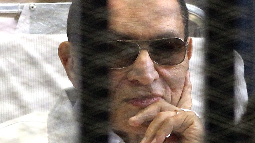 epa04507725 (FILE) A file photo dated 13 April 2013 shows former Egyptian President Hosni Mubarak (L) on a stretcher looking on from behind the bars of a cage inside the court room during his trial at ...